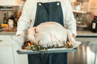 A fresh turkey on a tray, ready for cooking, embodies the Thanksgiving spirit indoors.